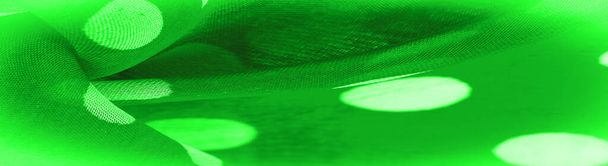 Σύνθεση φόντου, διακοσμητικό στολίδι, πράσινο πουά ύφασμα, στρογγυλές κουκκίδες σε ύφασμα που έχουν το σχήμα ή περίπου μοιάζουν με κύκλο ή κύλινδρο. - Φωτογραφία, εικόνα
