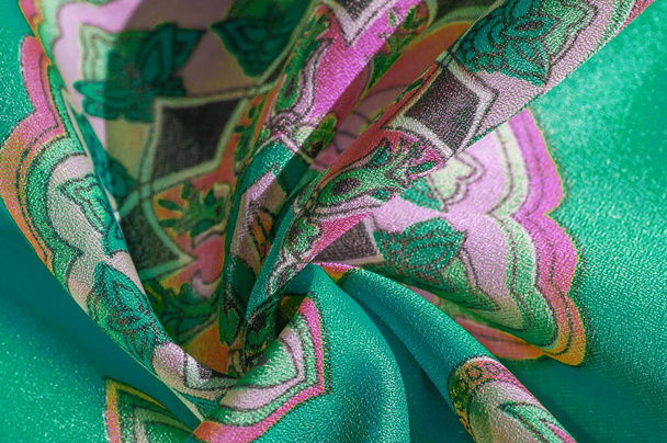 texture, background, multicolored silk fabric with a pattern of patterns on a green background, jacquard pattern - Photo, Image