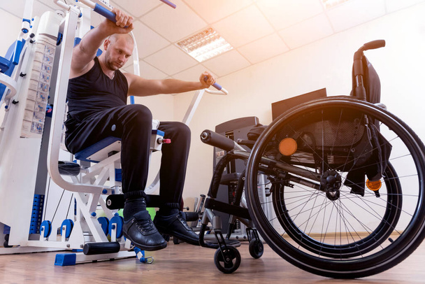 Disabled man doing strength exercises separate from the wheelchair. - Φωτογραφία, εικόνα