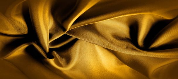 textura, fondo, patrón. foto panorámica de tela de seda de color amarillo dorado. Esta es la soleada Carolina. Esta es una mano suave que crea un brillo sutil. Hecho con seda de lujo, como la belleza
! - Foto, Imagen