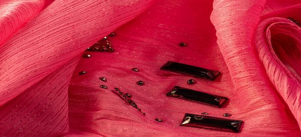 Textura de diseño de fondo, patrón de seda, tela rosa con piedras facetadas decorativas pegadas - Foto, Imagen