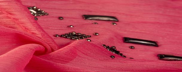 Achtergrond ontwerp textuur, zijde patroon, roze stof met gelijmde decoratieve facetten stenen - Foto, afbeelding