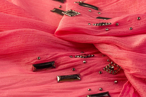 Texture de fond, motif en soie, tissu rose avec des pierres à facettes décoratives collées - Photo, image