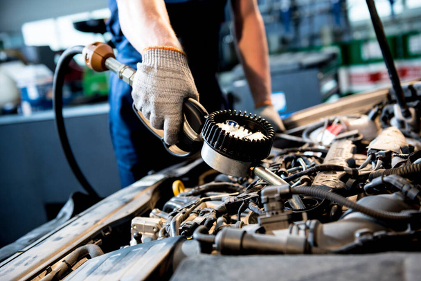 Car mechanic change engine oil. Car repair. Service station - Фото, изображение