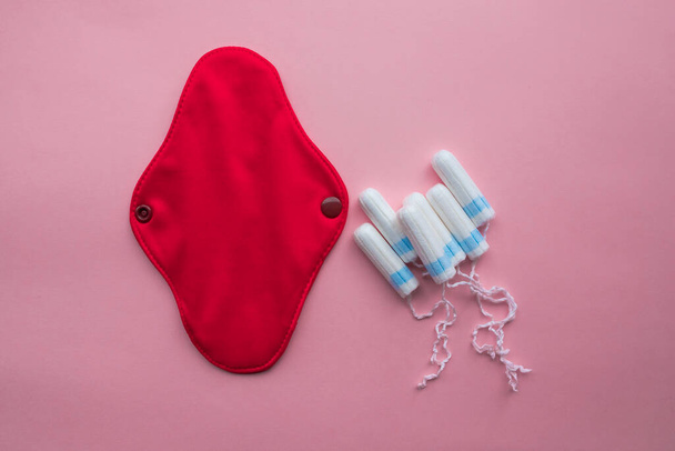 Reusable Cloth Sanitary Menstrual Pad and disposable tampon. Flat lay on pink background. Zero waste concept. Caring for the environment. Women Health. Conscious consumption. - Photo, image