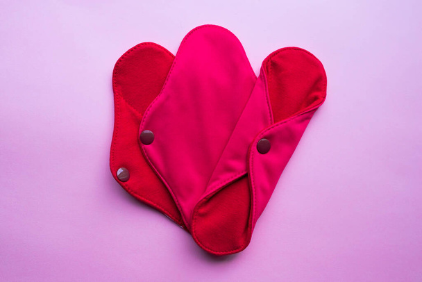 Reusable Cloth Sanitary Menstrual Pads. Flat lay top view on pink background. Zero waste concept. Caring for the environment. Women Health. Conscious consumption. Alternative to disposable pads. - Foto, Bild