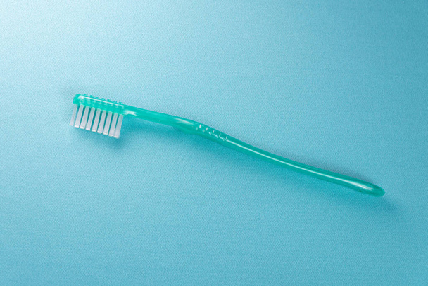 Green toothbrush on the blue background - Фото, зображення