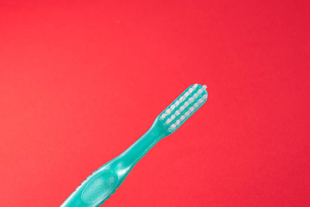 Cepillo de dientes verde sobre fondo rojo - Foto, Imagen