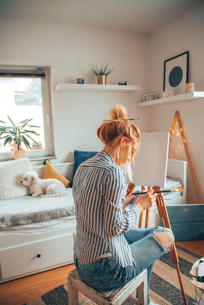 Όμορφη καλλιτέχνης γυναίκα ζωγραφική στο δωμάτιό της. - Φωτογραφία, εικόνα