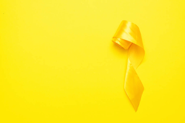 Yellow ribbon on the yellow flat lay background with copy space. - Foto, Imagen