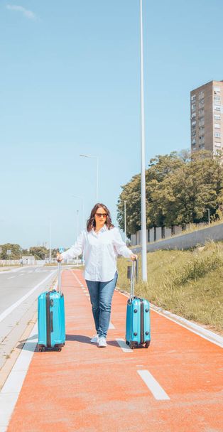 Подорожуюча жінка з багажем по дорозі в аеропорт
. - Фото, зображення