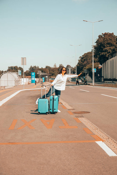 Femme en voyage avec des bagages sur le chemin de l'aéroport. - Photo, image