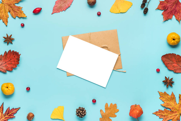 Thanksgiving autumn greeting card or invitation. Dried leaves, flowers, nuts, berries on blue background. Flat lay, mock up. top view with copy space - Photo, Image