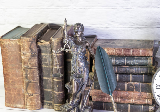Antique clock along with antique books and statuette of the goddess of justice. temis. - Fotoğraf, Görsel