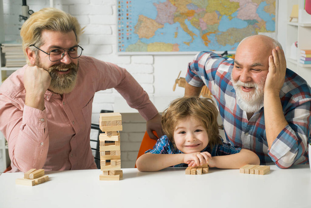 Father and son with grandfather was excited with playing game. Father and son playing Jenga with grandchild. - 写真・画像