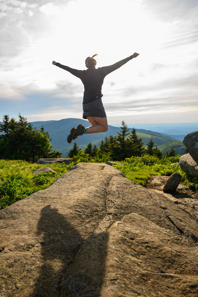 Γυναίκα πηδά από ογκόλιθο, ενώ κοιτάζοντας πάνω από Blue Ridge βουνά - Φωτογραφία, εικόνα