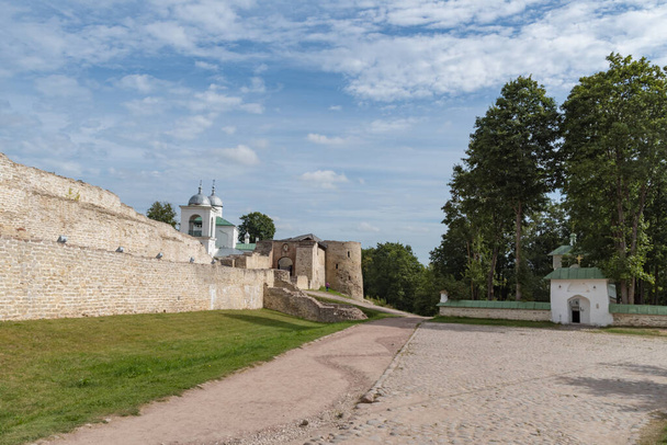 Kerk van St. Sergius van Radonezh en oude Izborsk fort, Nikolsky 's verdedigingsmouw, poorten en St. Nicolaas kathedraal van de 14e eeuw achter de versterkte muren. Pskov-regio, Rusland. - Foto, afbeelding