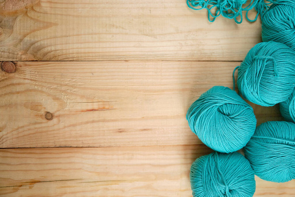 Balls of colored natural yarn in turquoise shades on a wooden background. Selective focus. Space for text. Copy space. Creativity and Hobbies. - Fotoğraf, Görsel