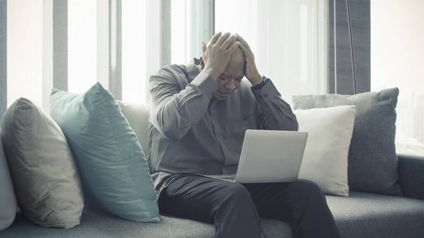 Business elderly black american man, African person working from home, thinking about problem with computer notebook laptop and suffering from depression in quarantine in corona virus pandemic concept - Foto, Bild