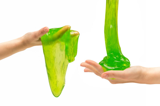Grünes Schleimspielzeug in Frauenhand isoliert auf weißem Grund. - Foto, Bild