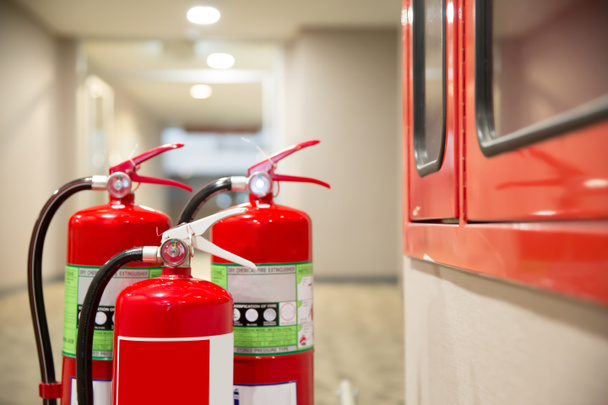 The red fire extinguisher is in the building. - Photo, Image