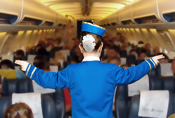 dziewczyna w stroju stewardessa wskazuje kierunek - Zdjęcie, obraz