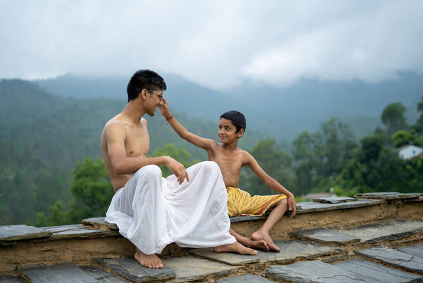 Молодий чоловік грає зі своїм молодшим братом з розмитими горами на спині
. - Фото, зображення