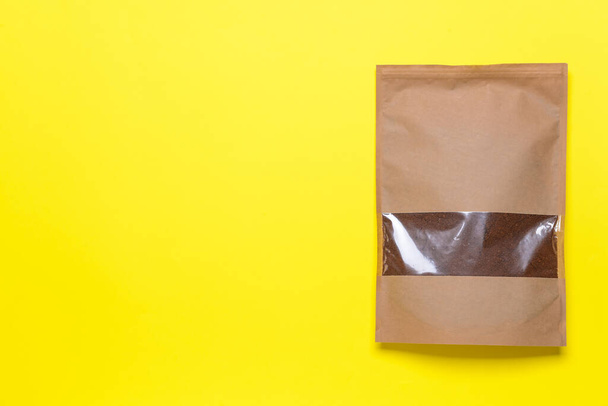 Bag with coffee powder on color background - Фото, зображення