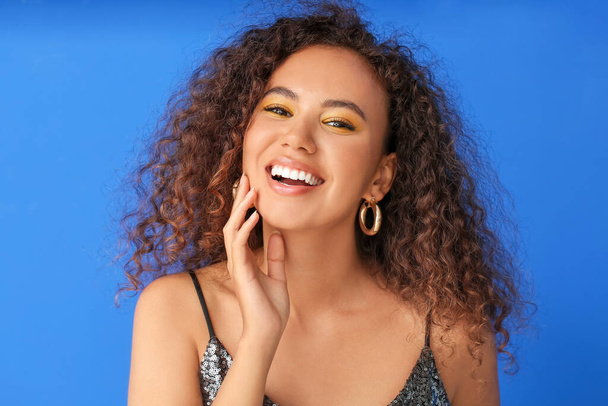 Young African-American woman with beautiful eyeshadows on color background - Φωτογραφία, εικόνα