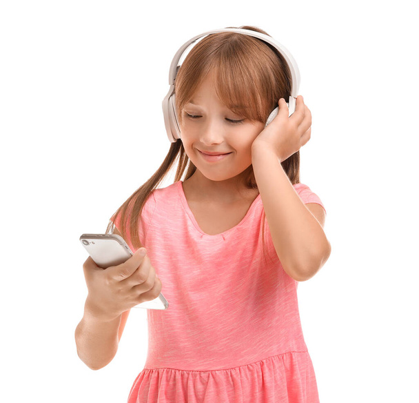 Little girl listening to music on white background - Фото, изображение