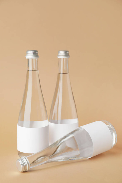 Bottles of clean water on color background - Fotó, kép