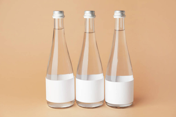 Μπουκάλια καθαρού νερού σε έγχρωμο φόντο - Φωτογραφία, εικόνα