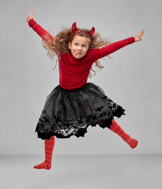 girl in halloween costume of devil jumping - Foto, imagen