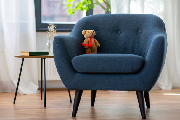 modern armchair with teddy bear toy at home - Фото, зображення