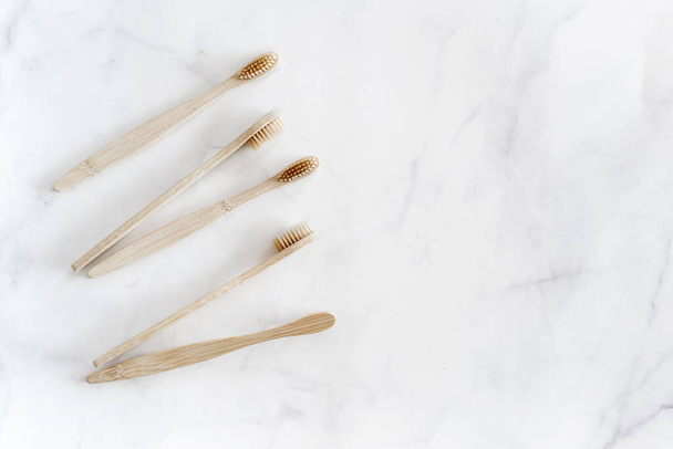Eco friendly bamboo toothbrushes on marble background. - Foto, imagen
