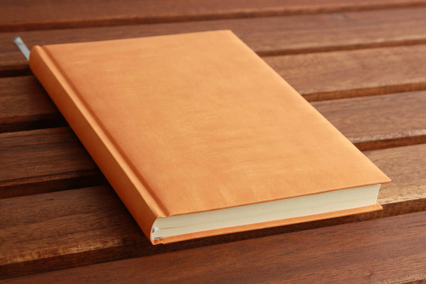 A closeup shot of a notebook with an orange cover - Fotó, kép