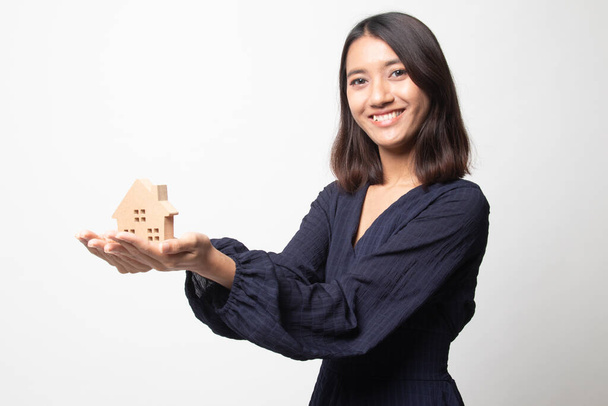 Happy young asian woman with house model on white background - Φωτογραφία, εικόνα