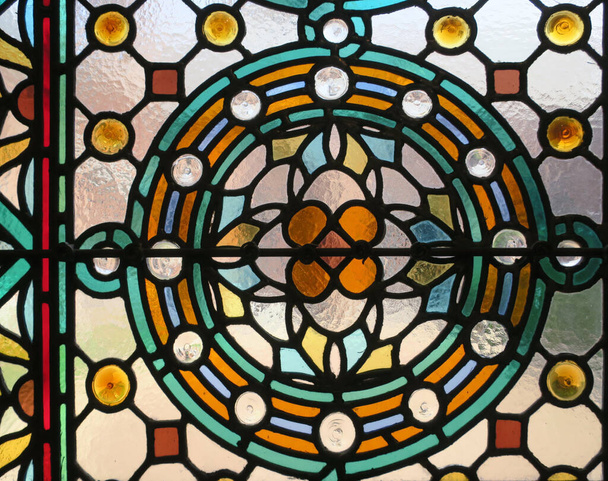 uma janela de vidro manchado multicolorido com um padrão de flor em um círculo - Foto, Imagem