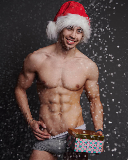 裸の若い男で赤いクリスマスと新年の贈り物 - 写真・画像