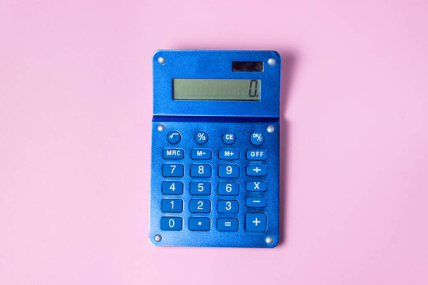 Blue calculator on a pink background. There is a place for an inscription and a logo - Photo, image