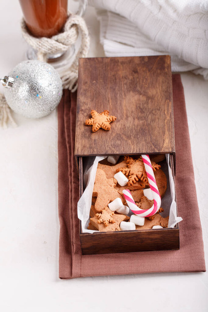 Gingerbread cookies, candy canes and marshmallow in wooden box. Holiday sweet gifts. Cozy winter vibes. Merry Christmas and Happy New Year. - Photo, Image