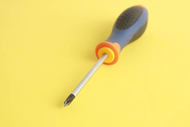 A tipped star screwdriver in orange, blue, and black colors - Fotoğraf, Görsel