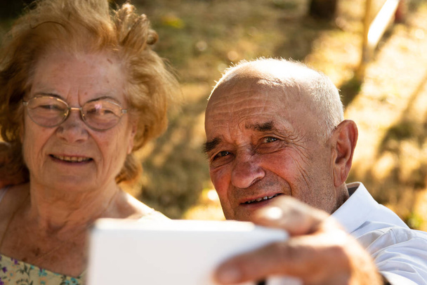 бабушка и дедушка или пожилая пара фотографируют на мобильный телефон - Фото, изображение