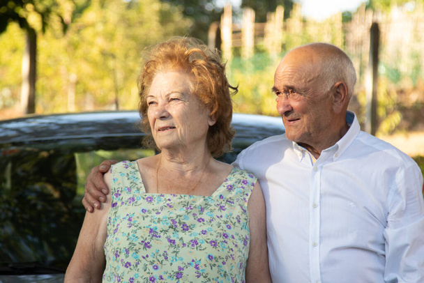retrato de pareja mayor con coche al aire libre - Foto, imagen