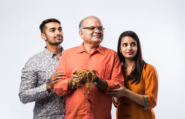 Indischer alter Mann mit jungem Sohn und Tochter oder Paar mit Goldschmuck, Schmuck - Asset or Gold Loan concept - Foto, Bild