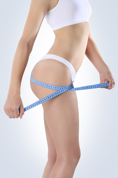 kobieta tyłek z miernika do diety na niebieskim tle - Zdjęcie, obraz