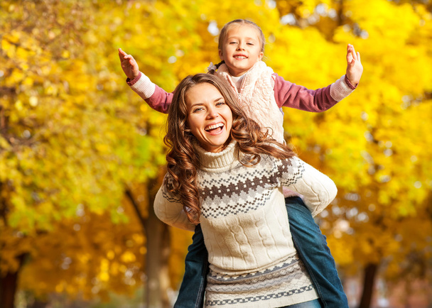 Mother and daughter having fun in the autumn park - Foto, Bild