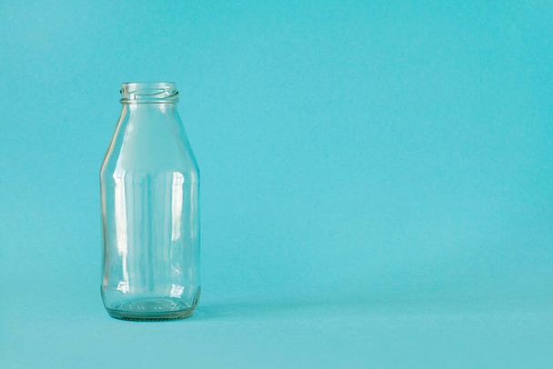 Empty milk bottle isolated on blue background, with place for text. Front view. Concept - Plastic free  - Photo, image