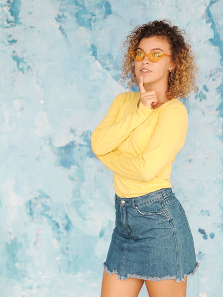 authentic portrait of pretty curly hair woman in sunglasses having fun indoors - Photo, Image