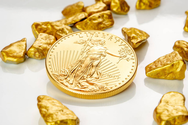 arany amerikai sas egy uncia érme feküdt egy halom arany rögök, aranyérc fehér háttér elszigetelt sok másolási hely - Fotó, kép